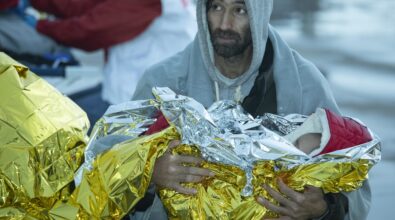 Il migrante che tiene in braccio suo figlio: lo sbarco di Roccella diventa un presepe vivente